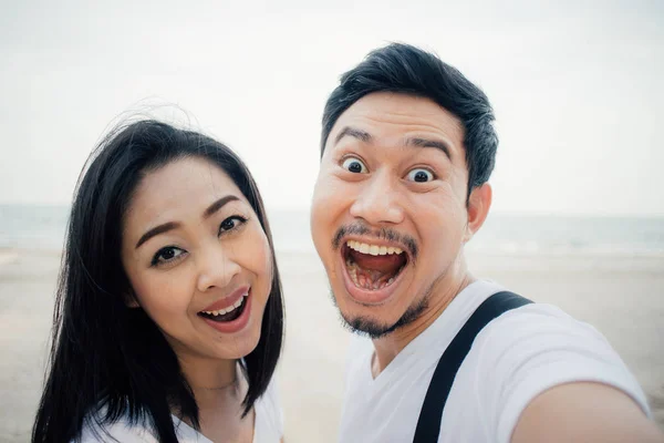 Wow face of asian couple tourist on romantic beach vacation trip.