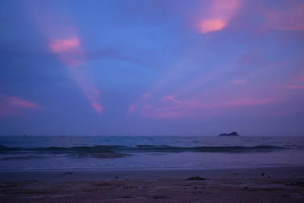 Vivid purple sky with light beam from sunset on the beach.