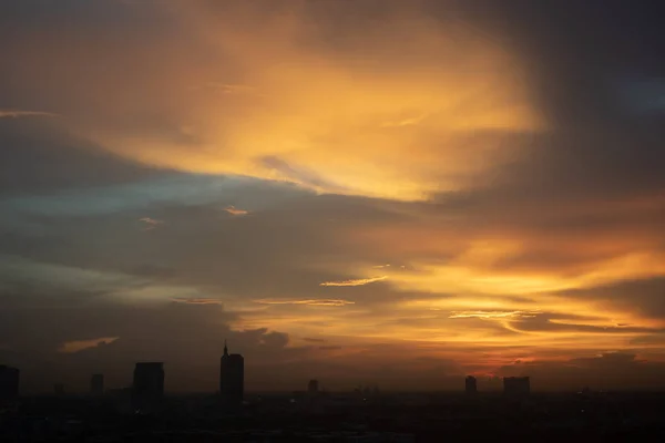 市内の曇り空の美しい黄金の夕日 — ストック写真