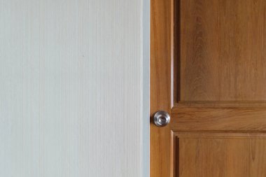 Basit kapı kolu boş duvar alanı ile ahşap bir kapı.