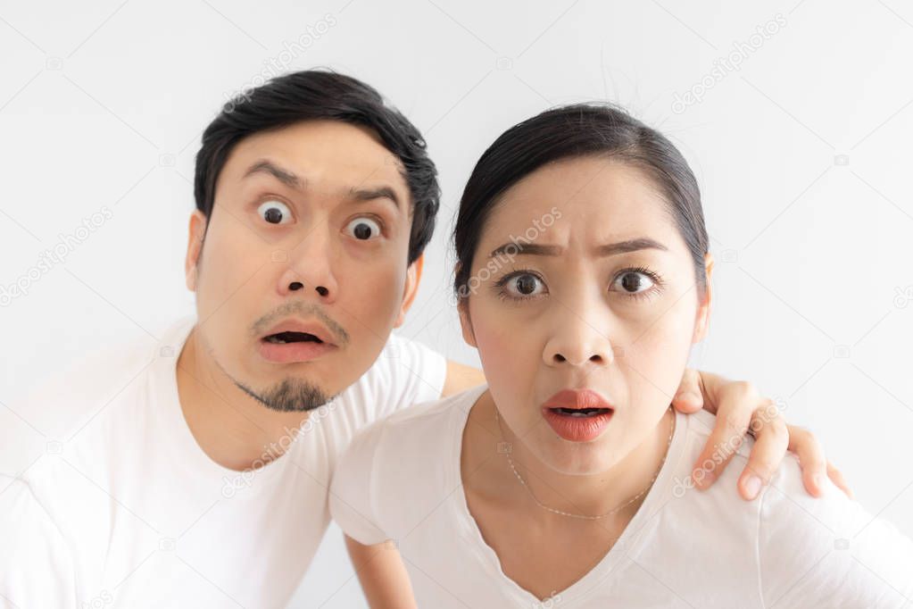 Funny face of Asian lovers couple in doubt at an unbelievable thing that they are looking at