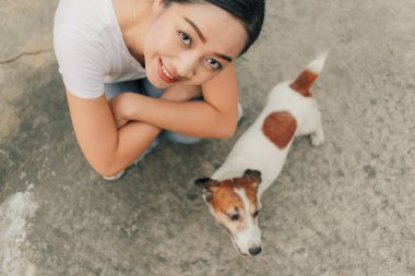 Mutlu Asyalı kadın köpeğini sokakta oynamak.