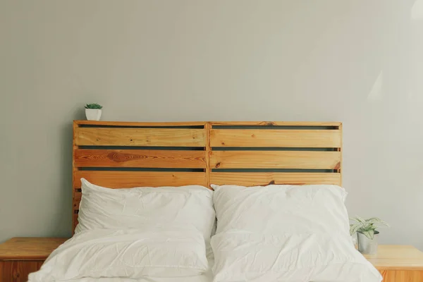 阁楼木制松木床头板与白色床和小锅植物 — 图库照片