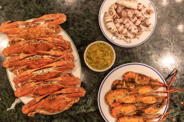 Buğulanmış squids çiçek yengeç ve karides soslu deniz mahsulleri setleri.