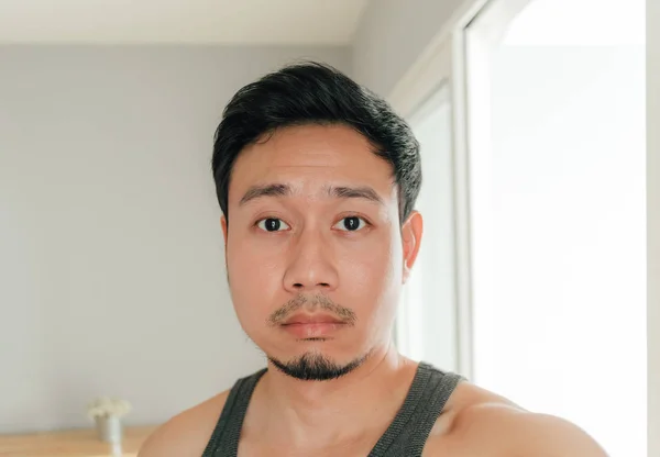 Sleepy and boring face of Asian man selfie himself in his room.