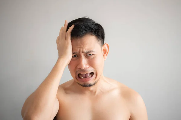 Cry and sad face of man in topless portrait isolated on gray background.