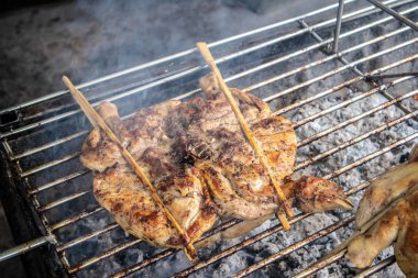 Tay bütün tavuk Caddesi üzerinde kömür ile ızgara yakın çekim.