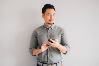 Yakışıklı Asyalı adamın gülen yüzü. Akıllı telefon kullan..