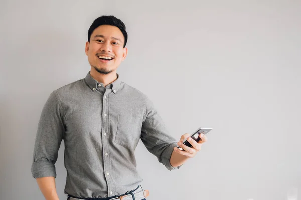 Asyalı adamın mutlu ve etkileyici yüzü akıllı telefon kullanıyor..