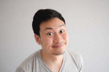 Komik zor garip sırıtış yüz Asyalı adamın gri t-shirt.