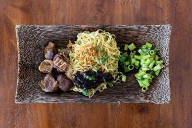 Domuz eti ve sos ile yumurta noodle klasik ahşap kase üzerinde hizmet.