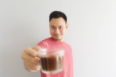 Kırmızı t-shirt içecekler kahve veya Asya otlar içecek Mutlu sağlıklı adam.