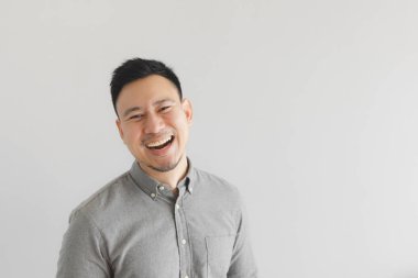 Gri gömlekli sıradan bir adamın mutlu ve gülen yüzü. Büyüleyici kahkaha kavramı.