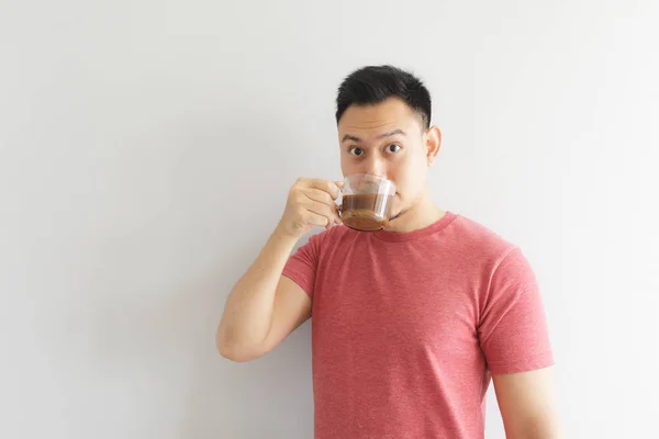 Felice uomo sano in rosso t-shirt beve caffè o erbe asiatiche bere . — Foto Stock