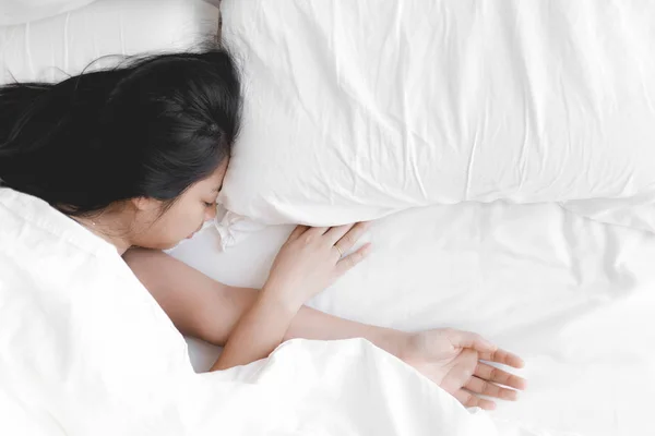 Wanita tidur nyenyak di tempat tidur putih. Konsep mencoba dan beristirahat . — Stok Foto