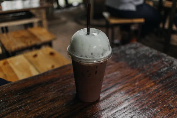 Cacao freddo e caffè in plastica serviti su tavolo di legno . — Foto Stock