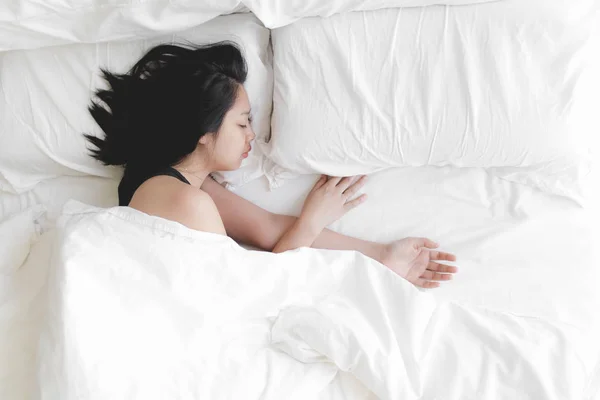 Woman has a deep sleep on white bed. Concept of tried and rest. — Stock Photo, Image