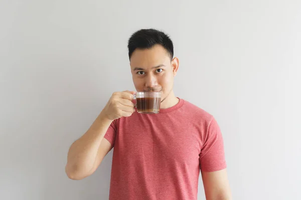 Felice uomo sano in rosso t-shirt beve caffè o erbe asiatiche bere . — Foto Stock