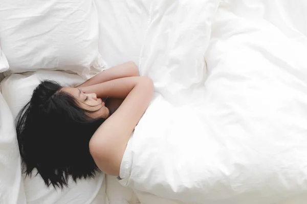 Vrouw heeft een diepe nachtrust op wit bed. Concept van beproefde en rust. — Stockfoto