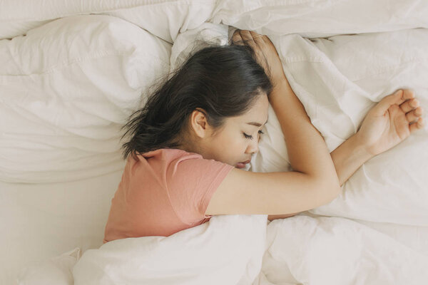 Tired woman rest and sleep in her warm bedroom.