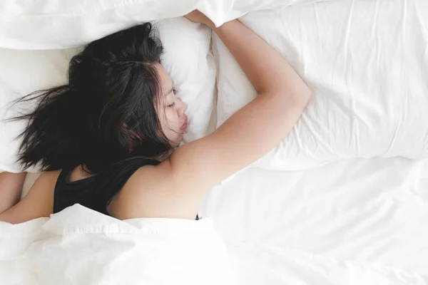 Η γυναίκα κοιμάται βαθιά στο λευκό κρεβάτι. Έννοια της δοκιμασμένης και ανάπαυσης. — Φωτογραφία Αρχείου