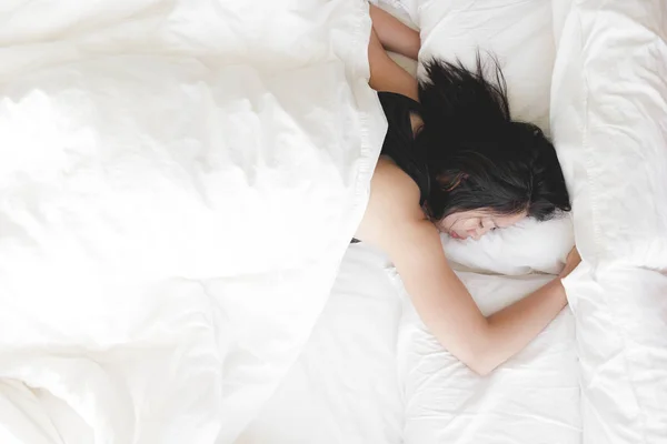 Kadının beyaz yatakta derin bir uykusu var. Denenmiş ve dinlenmiş kavramı. — Stok fotoğraf