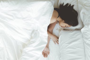 Kadının beyaz yatakta derin bir uykusu var. Denenmiş ve dinlenmiş kavramı.