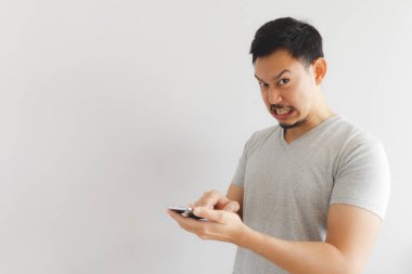 Gri tişörtlü kızgın adam akıllı telefona deli oluyor.