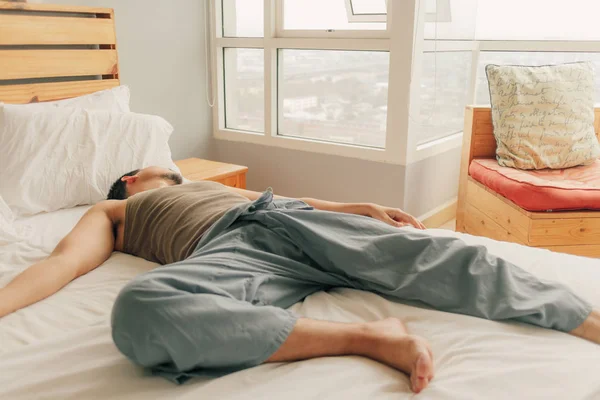 Asyalı adam yatakta yalan ve sıcaklık Pazar yaz bahar dairesinde dinlenmek. — Stok fotoğraf