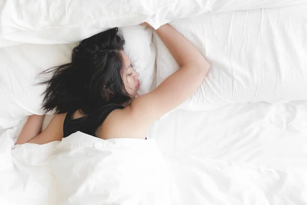 Η γυναίκα κοιμάται βαθιά στο λευκό κρεβάτι. Έννοια της δοκιμασμένης και ανάπαυσης. — Φωτογραφία Αρχείου
