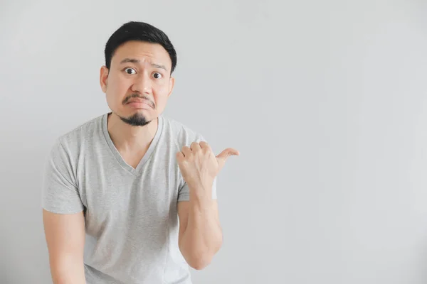 Boş alanda el noktası ile gri t-shirt adam nefret yüzü.