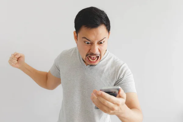 愤怒的男子在灰色T恤上发疯的智能手机. — 图库照片