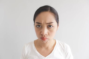 Beyaz tişörtlü kadının sulk ve huysuz yüz ifadesi. Rahatsız peevish ve somurtkan kavramı.