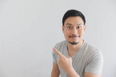 Boş alanda el noktası ile gri t-shirt adam mutlu yüzü.