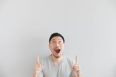 Wow ve boş alanda el noktası ile gri t-shirt adam sürpriz yüzü.