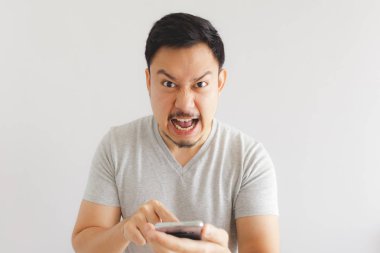 Gri tişörtlü kızgın adam akıllı telefona deli oluyor.