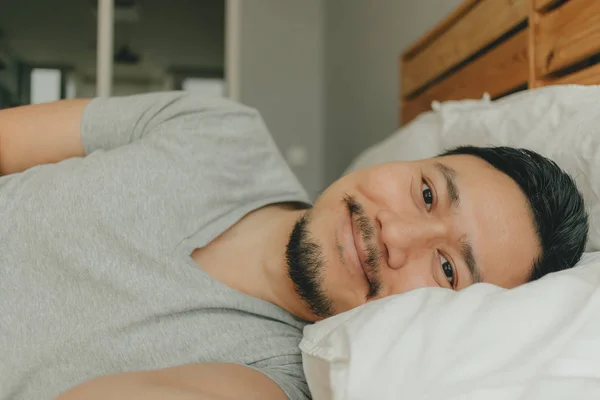 행복한 미소 얼굴로 침대에서 자고있는 남자를 닫습니다. 행복한 깊은 수면의 개념. — 스톡 사진