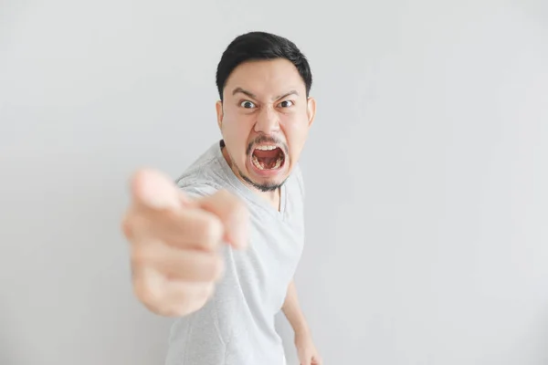 Angry face of man in grey t-shirt with hand point on empty space. — Stock Photo, Image