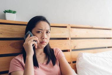 Üzgün kadın yatağında bir telefon görüşmesi var.