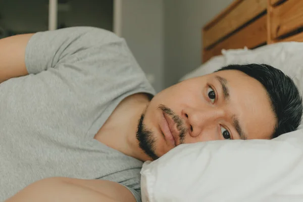 Acercarse hombre durmiendo en su cama con la cara preocupada. Concepto de preocupación y angustia . — Foto de Stock