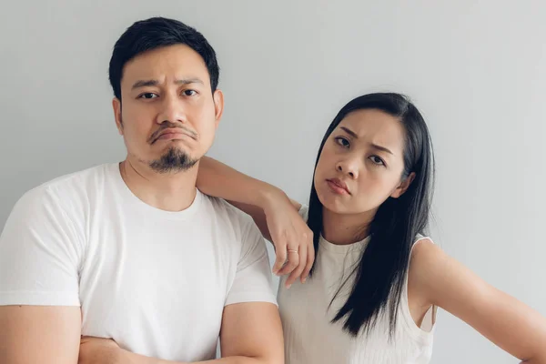 Sad couple lover in white t-shirt and grey background.