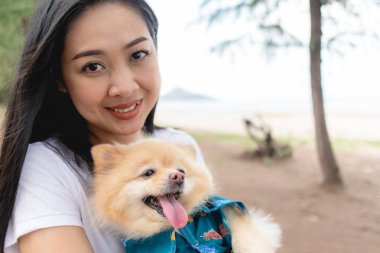 Mutlu kadın elinde pomeranian bir köpek tutuyor. İnsan en iyi arkadaş kavramı.