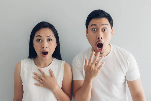 Beyaz t-shirt ve gri arka plan sürpriz ve şok çift sevgilisi.