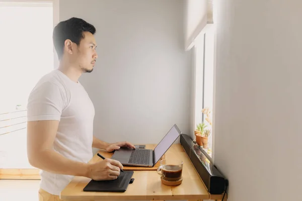 Freelancer man is working on his laptop in his apartment. Concept of freelance creative works. — Stock Photo, Image