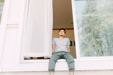 Adam oturup yaz aylarında evin ön kapısında dinlenmek. Tek adam yaşamı kavramı.