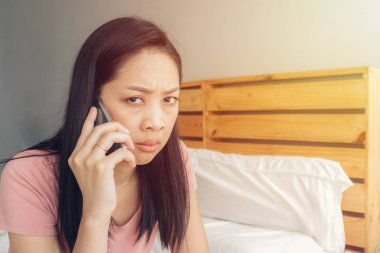 Üzgün kadın yatağında bir telefon görüşmesi var.