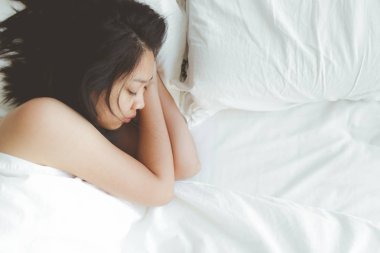Kadının beyaz yatakta derin bir uykusu var. Denenmiş ve dinlenmiş kavramı.