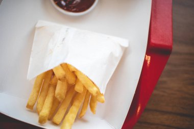 Franchise kafede servis edilen domates soslu kağıt torbada Patates Kızartması.