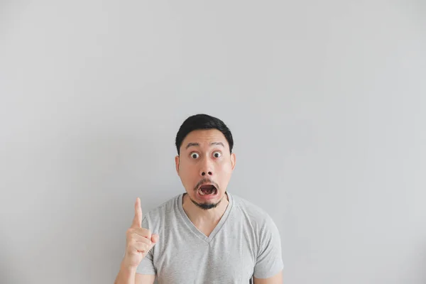 Shocked face of man in grey t-shirt with hand point on empty space. — Stock Photo, Image