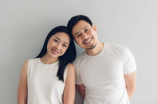Feliz casal amante em branco t-shirt e fundo cinza . — Fotografia de Stock